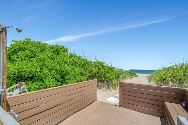 exterior space with a balcony, a view of the beach, and a water view