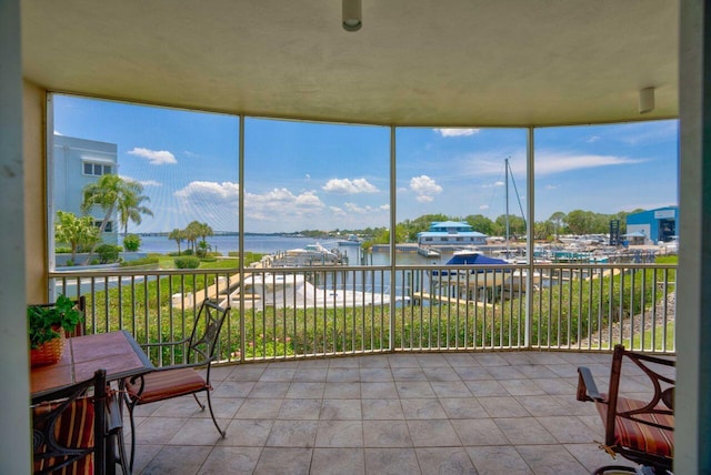 sunroom featuring a water view and a wealth of natural light