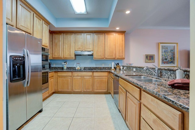 kitchen featuring stainless steel appliances, sink, a raised ceiling, dark stone countertops, and light tile patterned flooring