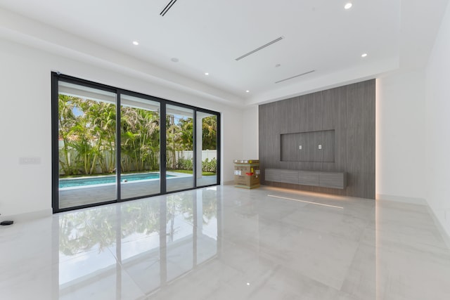 empty room with a fireplace and a wealth of natural light