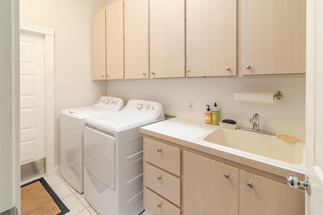 washroom featuring cabinets, sink, light tile patterned floors, and washer and clothes dryer