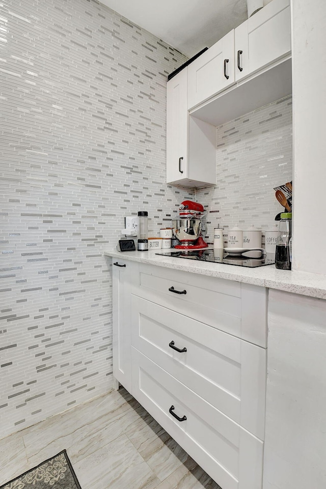 bar featuring white cabinets, tile walls, light stone countertops, and light tile patterned floors