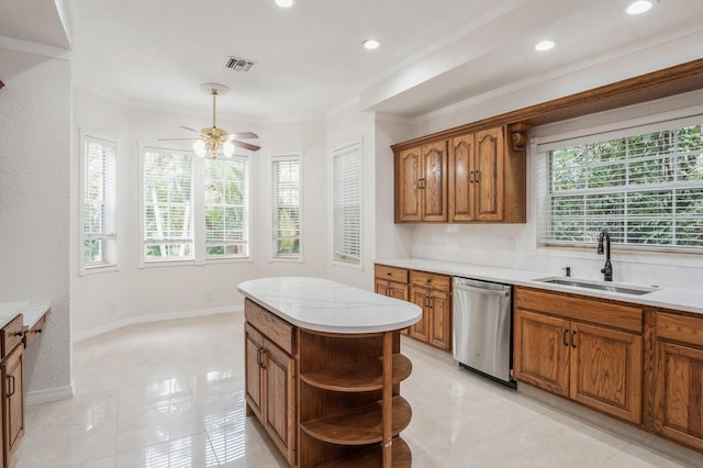 kitchen featuring dishwasher, a center island, crown molding, sink, and ceiling fan