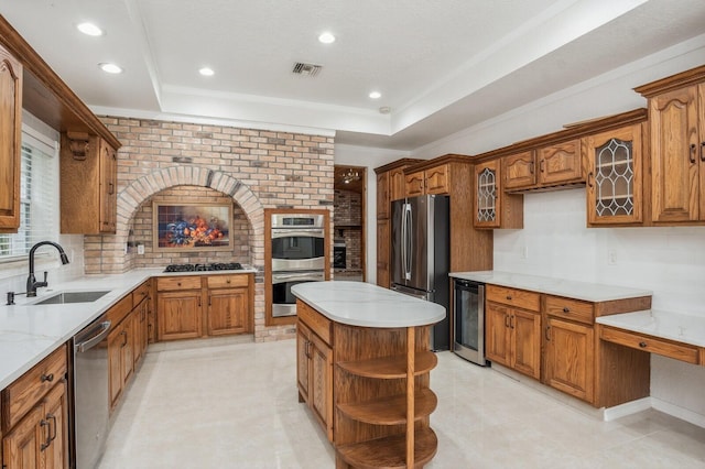 kitchen with a kitchen island, wine cooler, appliances with stainless steel finishes, a tray ceiling, and sink