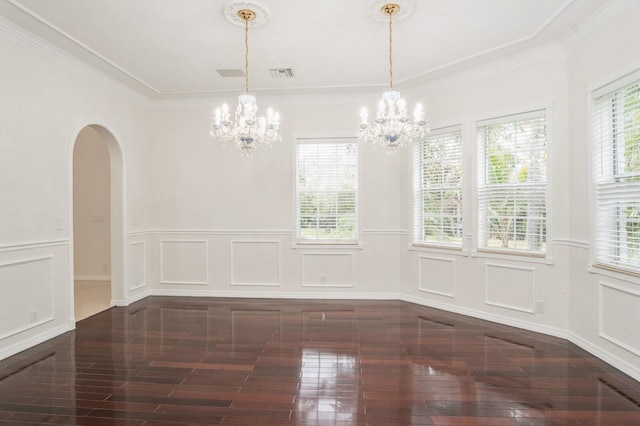 empty room with dark hardwood / wood-style floors, an inviting chandelier, and ornamental molding