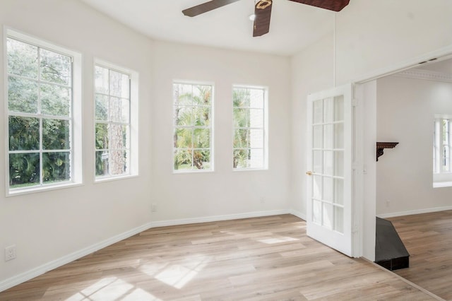 spare room with a wealth of natural light, ceiling fan, and light hardwood / wood-style floors