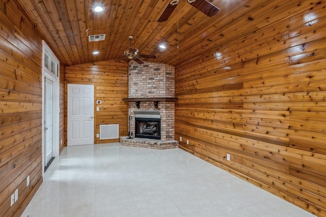 unfurnished living room with vaulted ceiling, wood walls, wooden ceiling, a brick fireplace, and ceiling fan