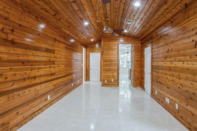 spare room with wood walls, ceiling fan, wooden ceiling, and vaulted ceiling