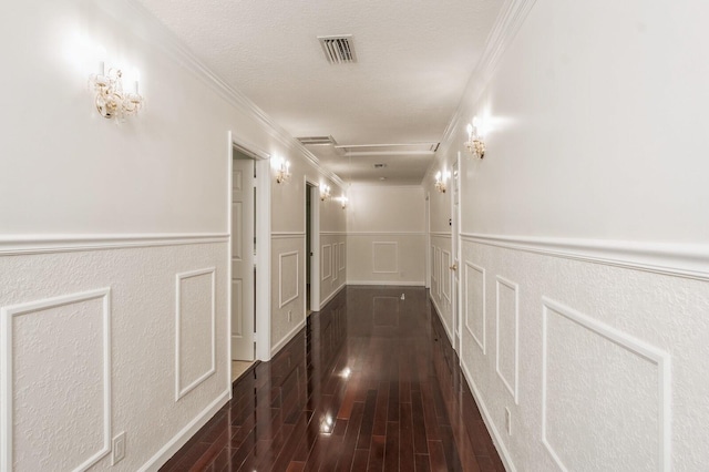 corridor featuring ornamental molding, a textured ceiling, and dark hardwood / wood-style floors