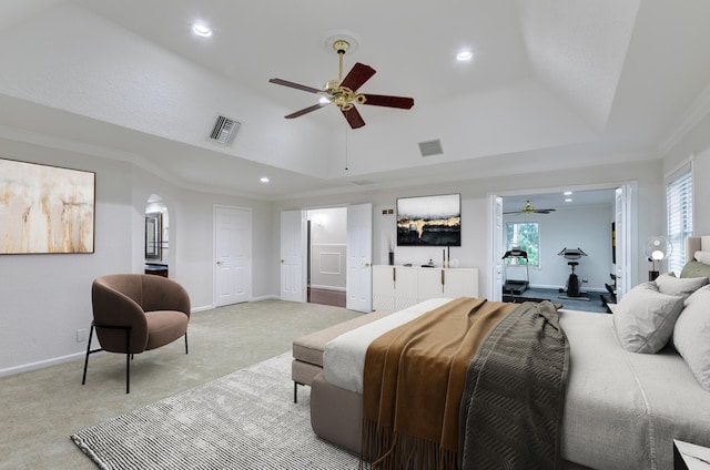 bedroom with ornamental molding, light colored carpet, a tray ceiling, and ceiling fan