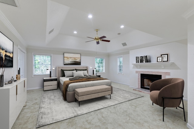 bedroom with light colored carpet, ceiling fan, ornamental molding, and a tray ceiling