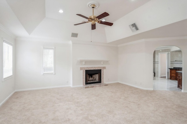 unfurnished living room featuring ceiling fan, light carpet, and ornamental molding