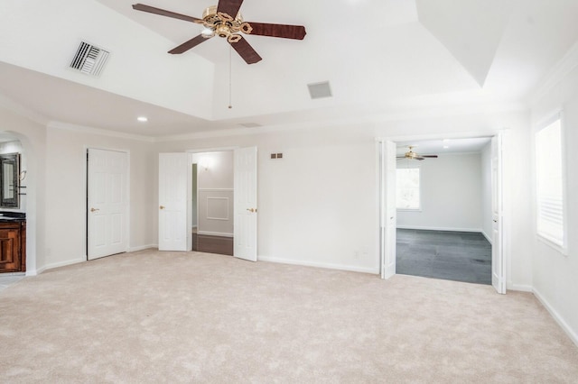 unfurnished bedroom featuring ceiling fan, ornamental molding, light carpet, and ensuite bathroom