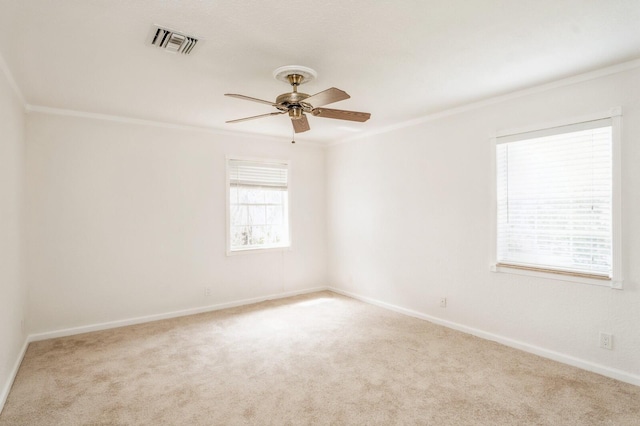 spare room with crown molding, ceiling fan, and light colored carpet