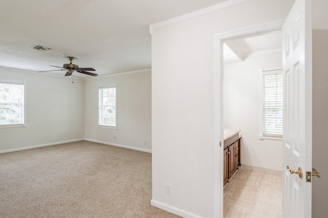 carpeted spare room with ceiling fan and crown molding