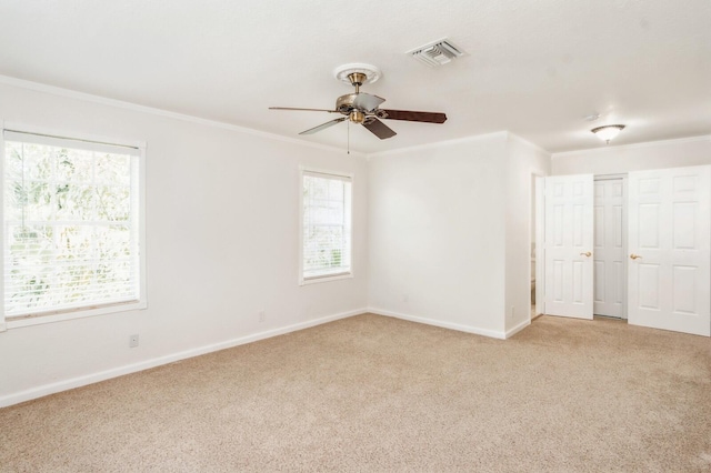 empty room featuring crown molding, light colored carpet, and ceiling fan