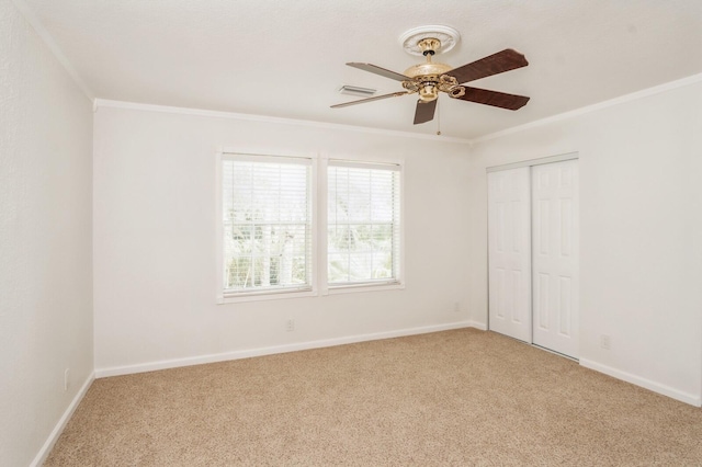 spare room featuring crown molding, ceiling fan, and light carpet