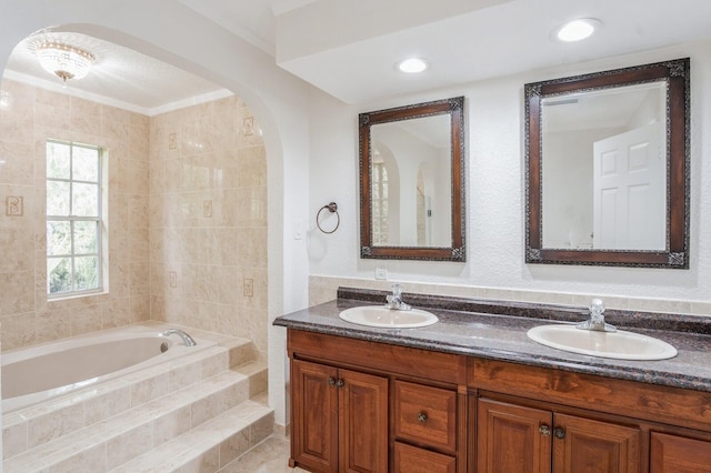 bathroom featuring vanity and tiled tub