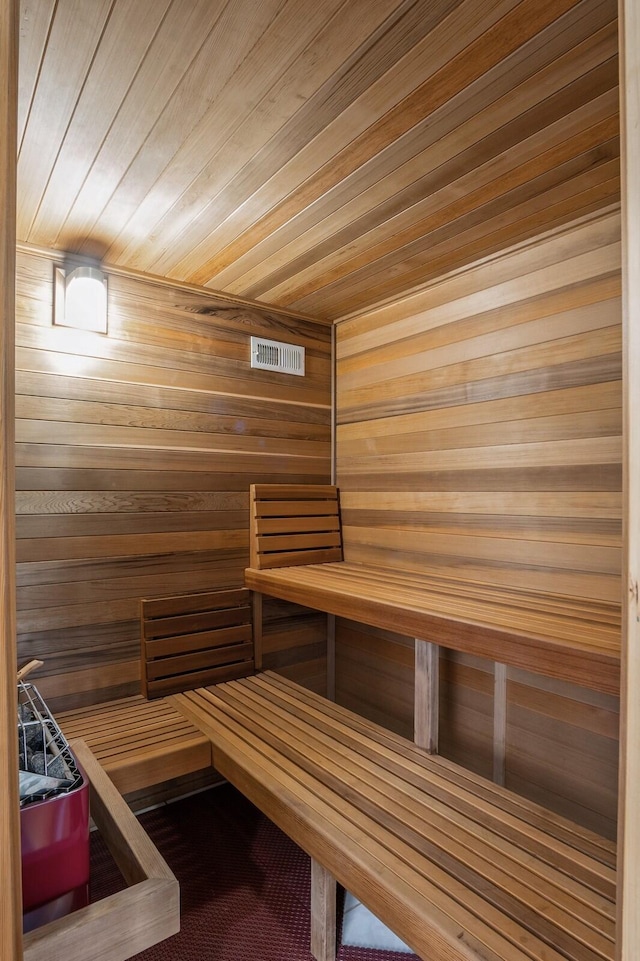 view of sauna featuring wood ceiling and wooden walls