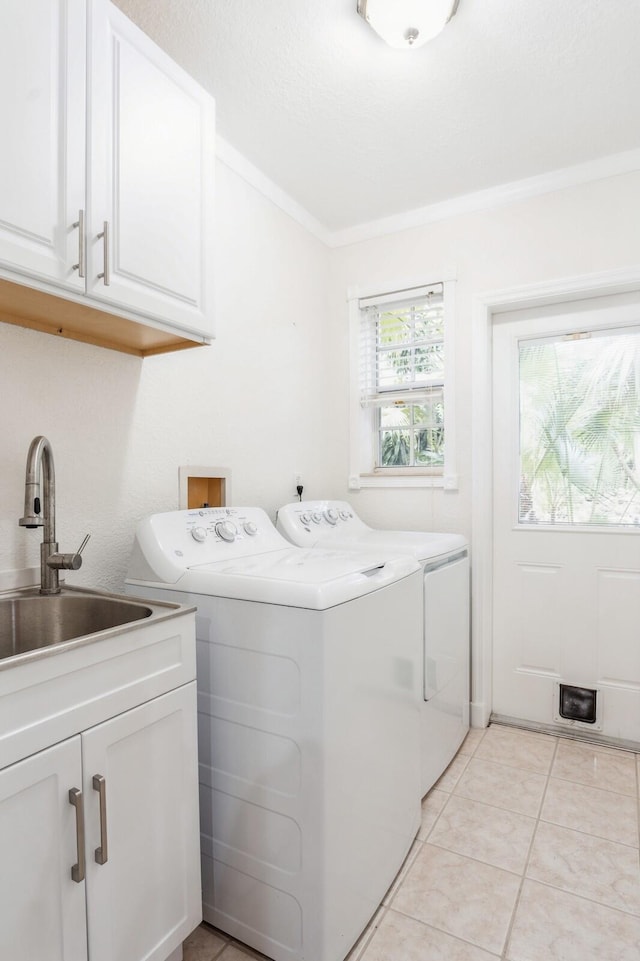 washroom featuring crown molding, independent washer and dryer, sink, light tile patterned flooring, and cabinets