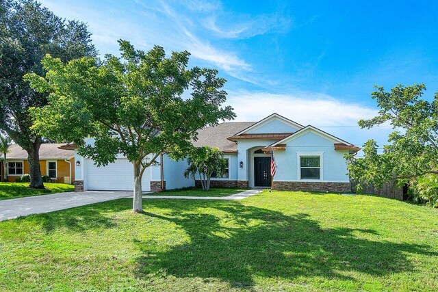 view of front of house with a front yard and a garage