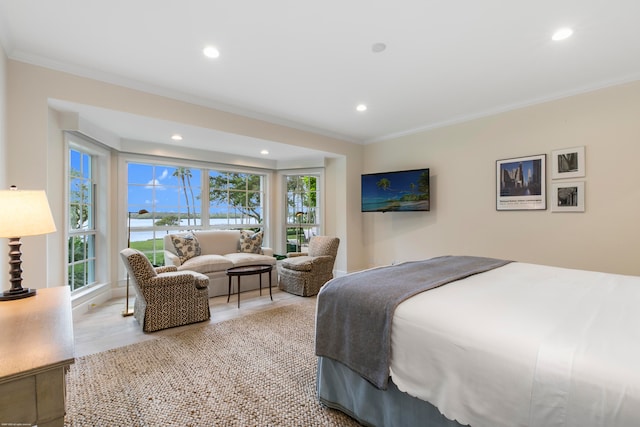 bedroom with crown molding, light hardwood / wood-style flooring, and multiple windows