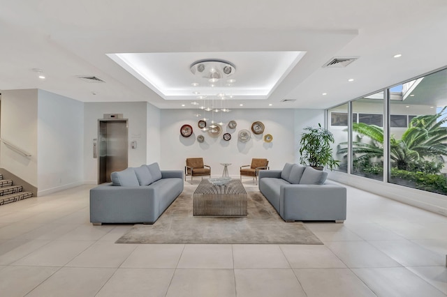 tiled living room with expansive windows, elevator, and a tray ceiling