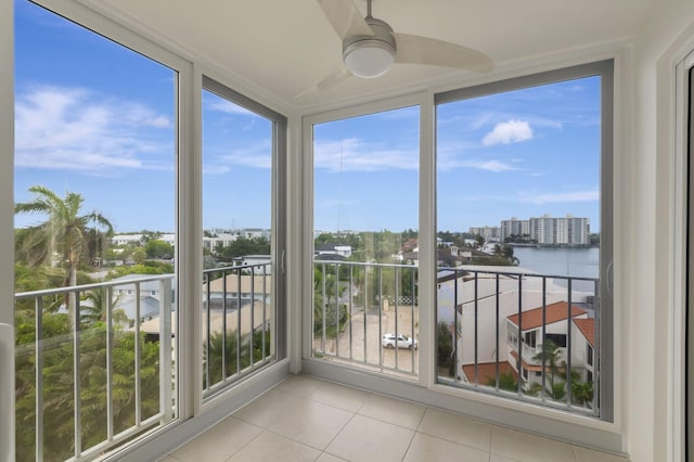 unfurnished sunroom with a water view, ceiling fan, and a healthy amount of sunlight