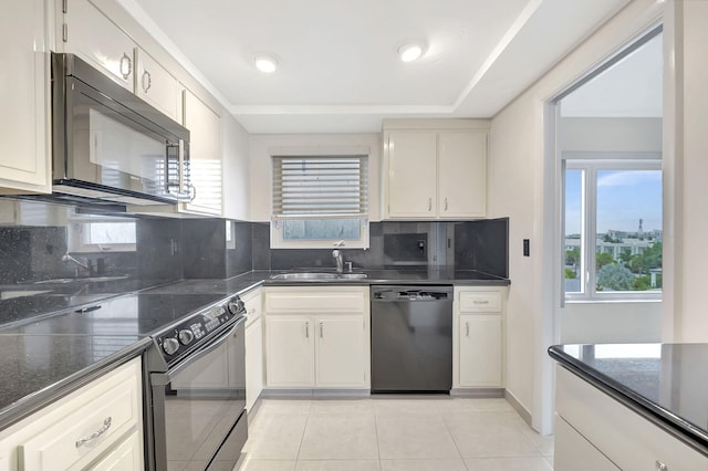 kitchen featuring decorative backsplash, dark stone counters, sink, black appliances, and light tile patterned flooring