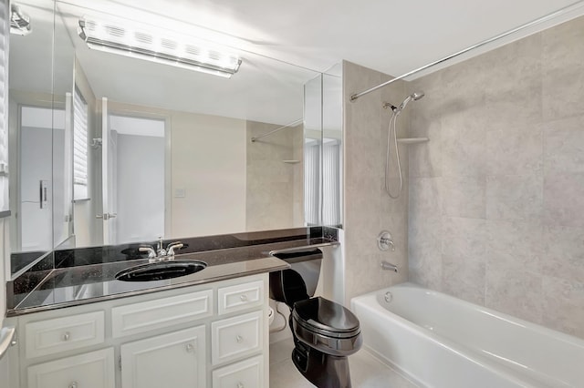 full bathroom featuring tile patterned flooring, toilet, tiled shower / bath, and vanity