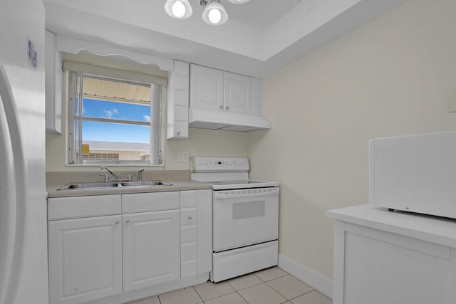 kitchen with sink, light tile patterned floors, white cabinets, range, and white fridge