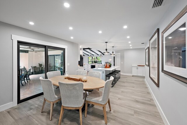 living room with light hardwood / wood-style flooring and vaulted ceiling with beams