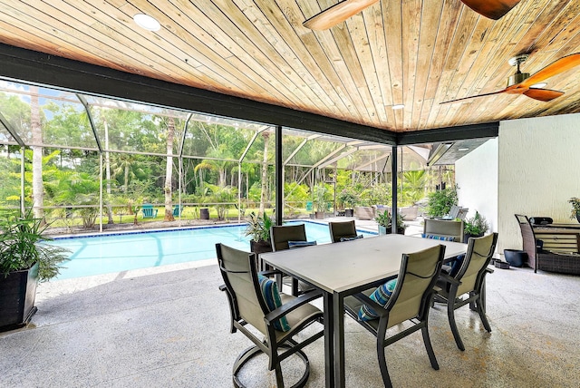 view of swimming pool featuring a patio, ceiling fan, and glass enclosure