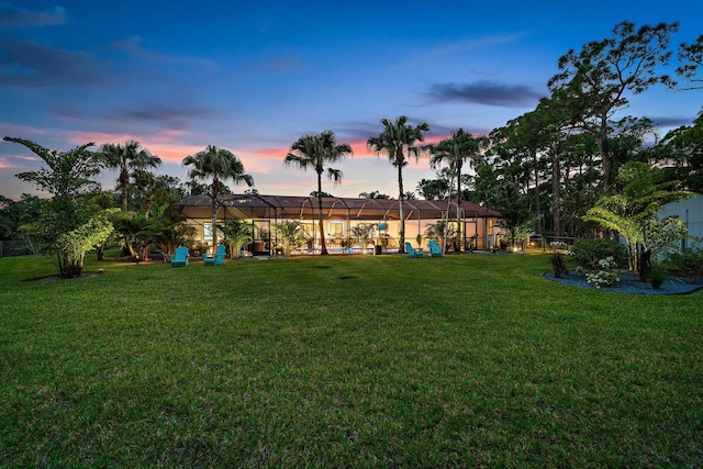 yard at dusk featuring glass enclosure