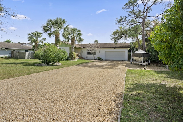 single story home with fence, a front lawn, driveway, and a garage