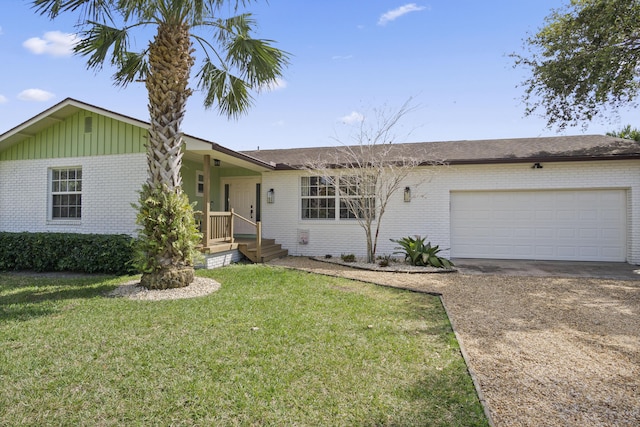 ranch-style home featuring brick siding, driveway, a garage, board and batten siding, and a front yard