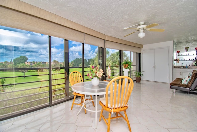 sunroom featuring ceiling fan and a healthy amount of sunlight