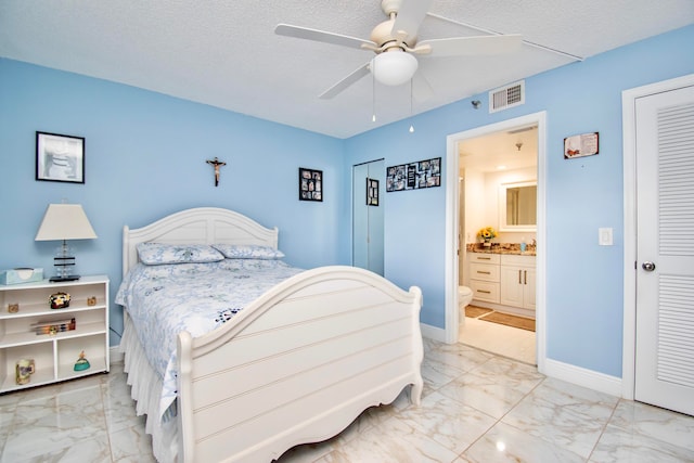 tiled bedroom with ensuite bath, a textured ceiling, and ceiling fan