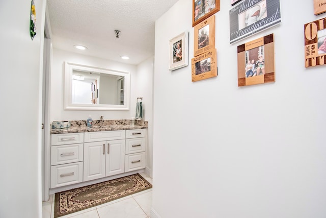 bathroom with vanity, a textured ceiling, and tile patterned flooring