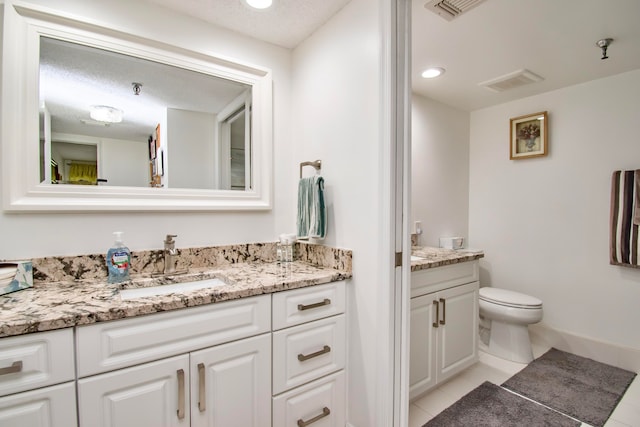 bathroom featuring vanity, a textured ceiling, toilet, and tile patterned flooring