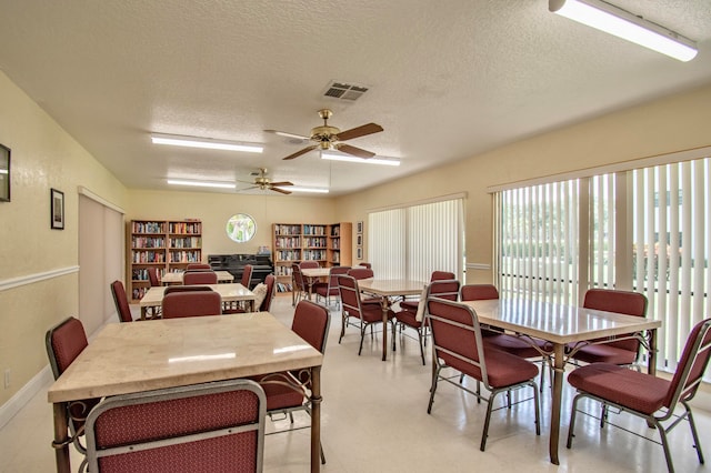 dining room featuring a textured ceiling, light tile patterned floors, and ceiling fan