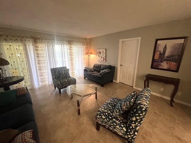 living room featuring light tile patterned flooring and a textured ceiling