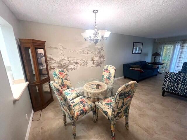 dining room with a textured ceiling and a chandelier