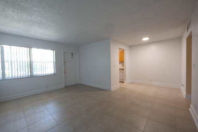 tiled spare room with a textured ceiling