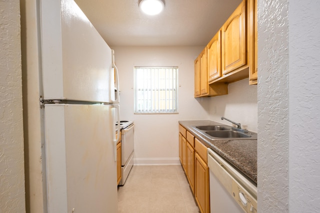 kitchen featuring white appliances, sink, and light tile patterned floors