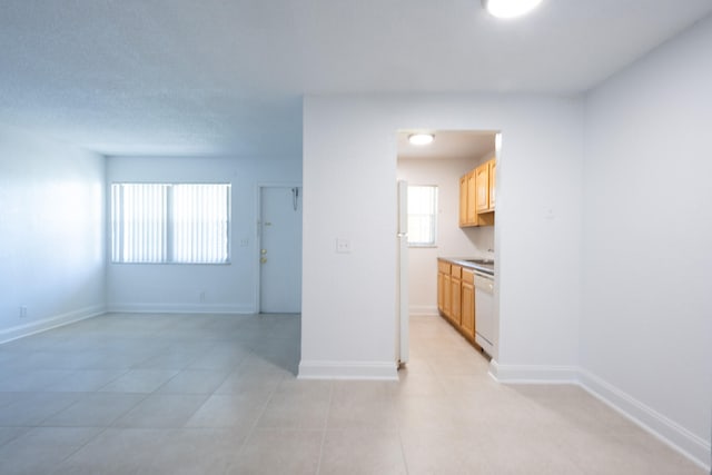 kitchen featuring dishwasher, sink, and light tile patterned floors