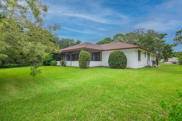 view of front of home featuring a front lawn and a sunroom