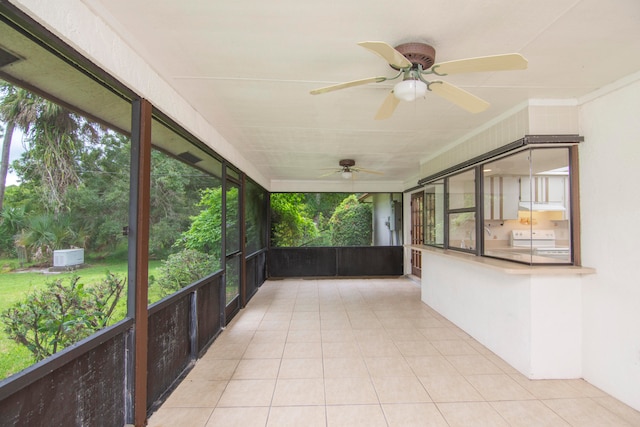 unfurnished sunroom featuring ceiling fan and plenty of natural light