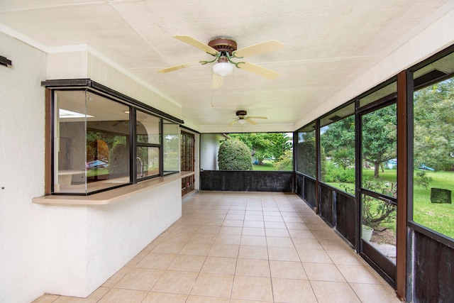 unfurnished sunroom with ceiling fan and a healthy amount of sunlight