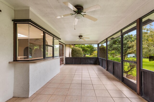 unfurnished sunroom with ceiling fan and a wealth of natural light